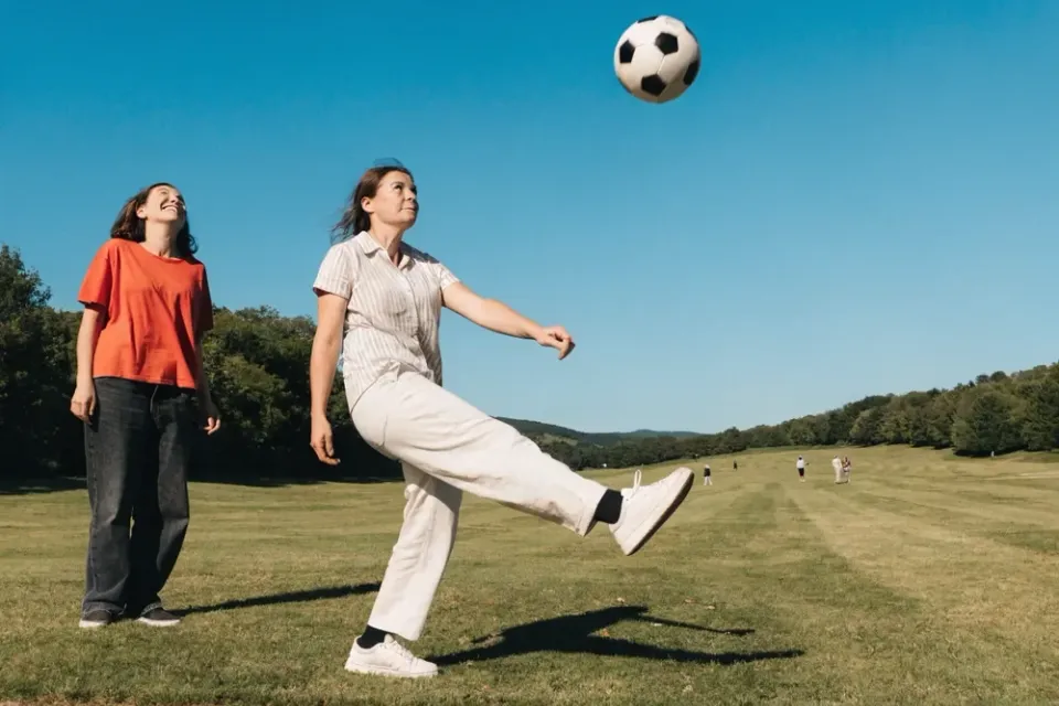 Fußballgolf: Abschlag mit dem Fußball auf der Wiese